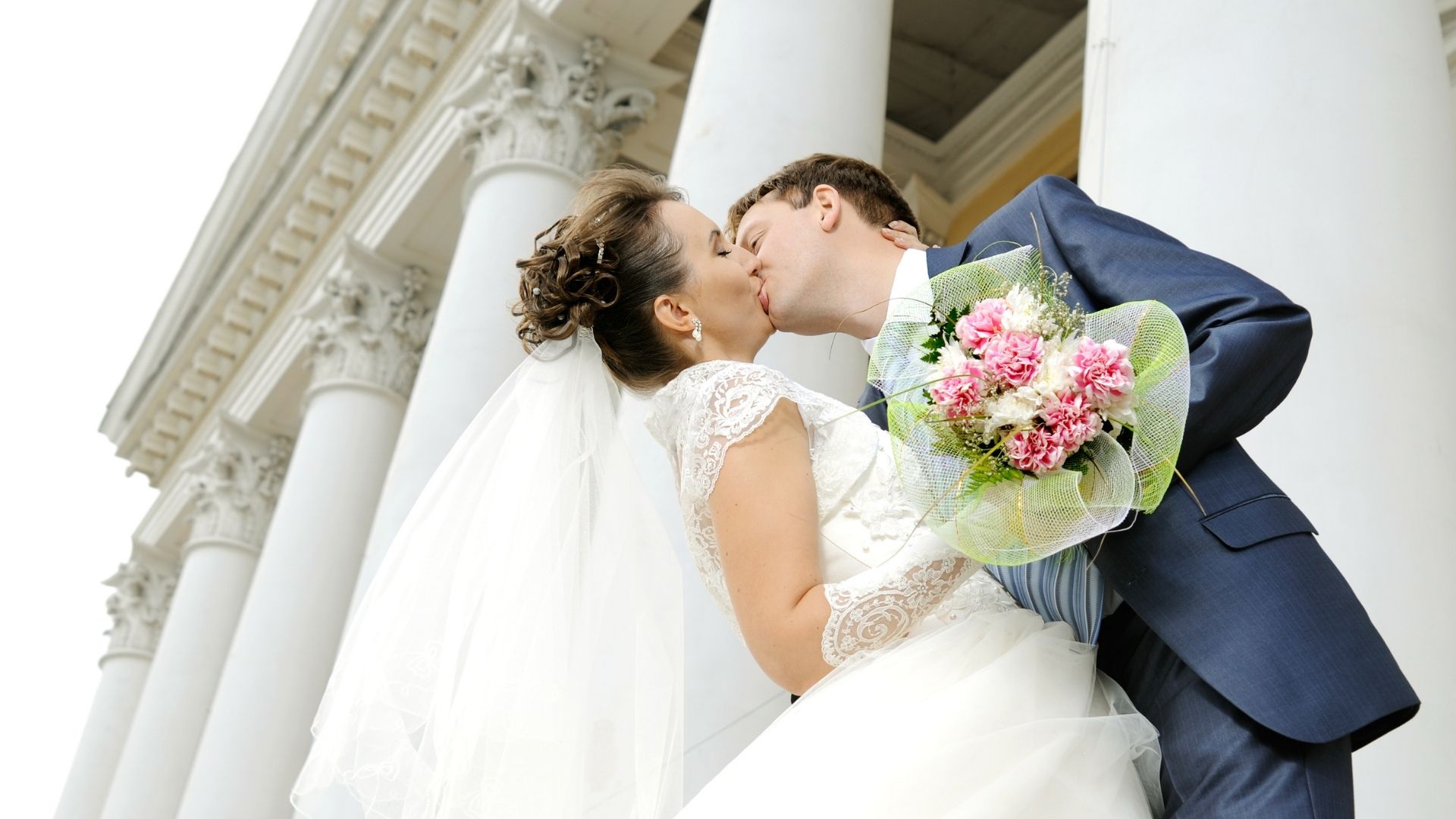 Bride and groom on the steps of a grand Cambridge wedding venue