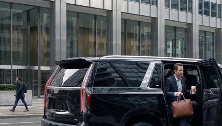 Billy Bishop Airport Private Car Service 7 Black Cadillac Escalade at a Financial District office curb, a business traveller at the open rear door for a connecting transfer