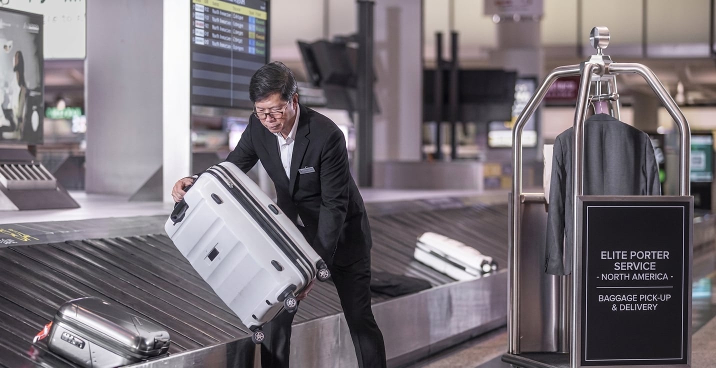 Airport porter handling premium luggage at baggage carousel YYZ