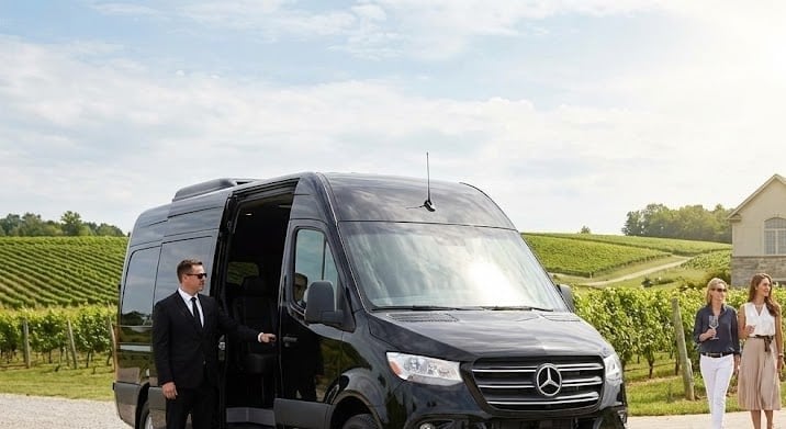 Guests with a black Mercedes-Benz Sprinter at a Niagara vineyard tasting stop