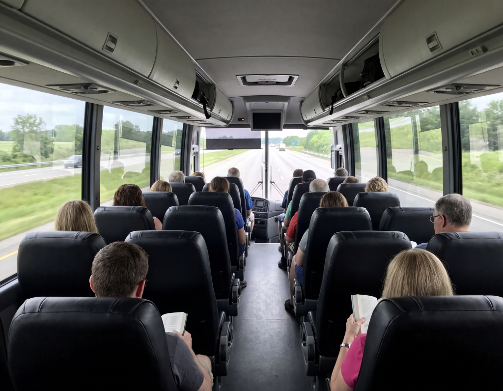 Guests settled into reclining seats inside a black motorcoach cabin
