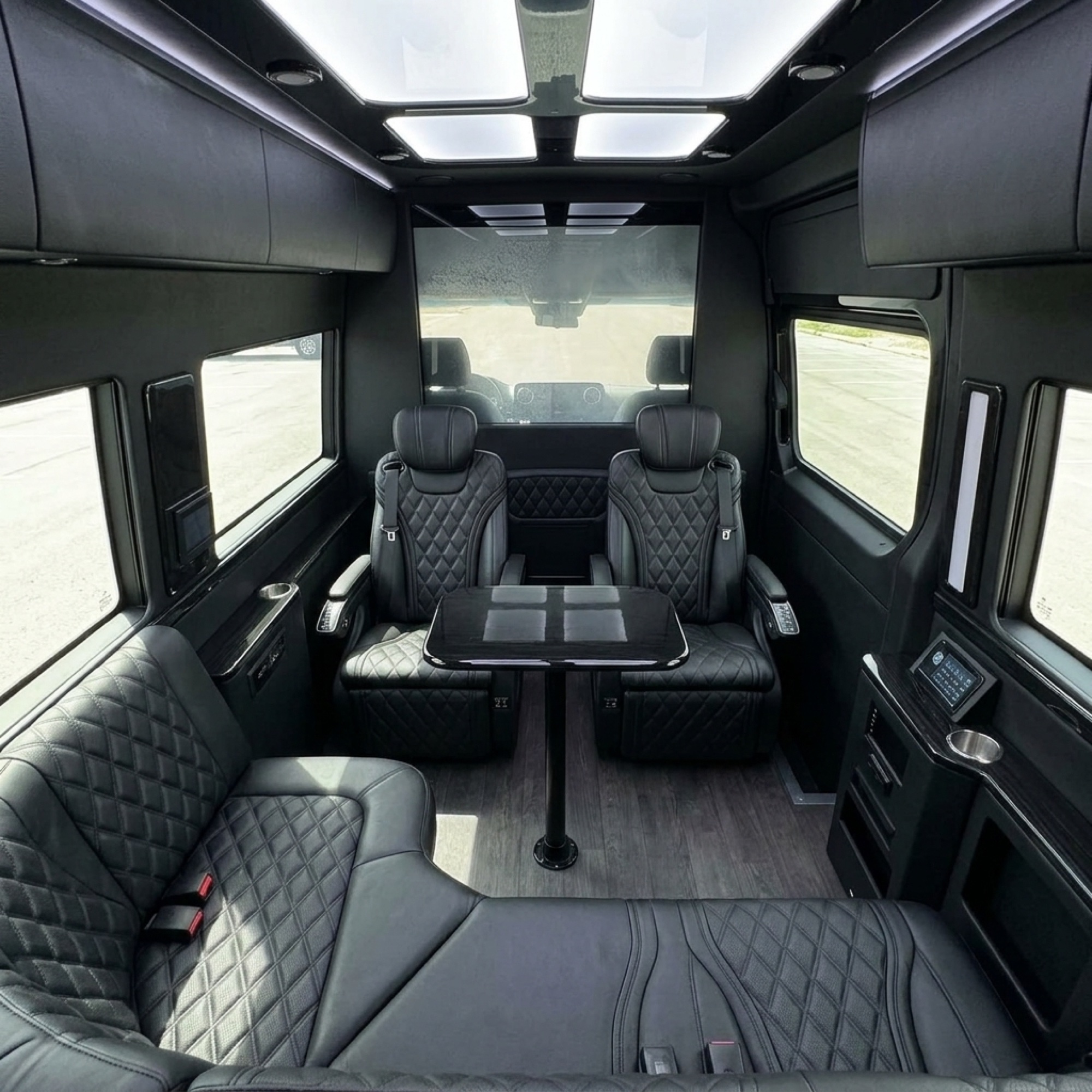 How Much Does a Sprinter Van with Driver Cost in Toronto? 5 LUX Mercedes-Benz Sprinter cabin with captain's chairs facing a table