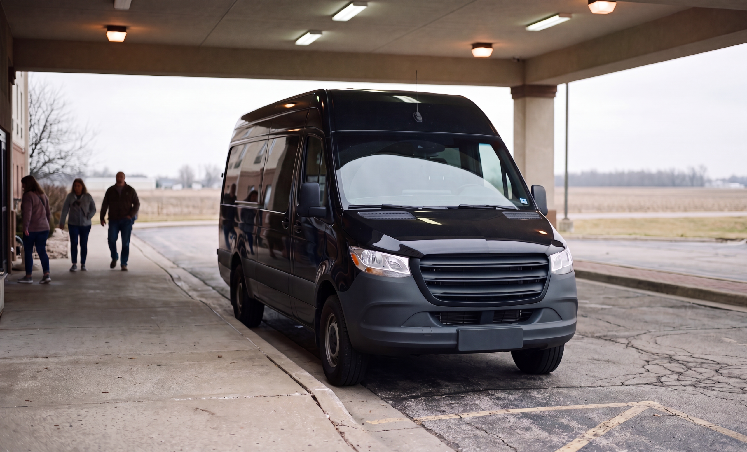 Black group van staged at a covered passenger pickup point before an Ontario trip